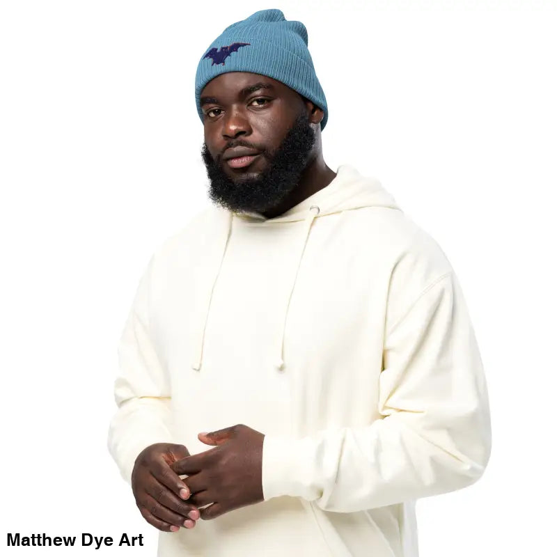 Man in a blue beanie and cream hoodie showcasing the Bat Baby Beanie for autumn warmth