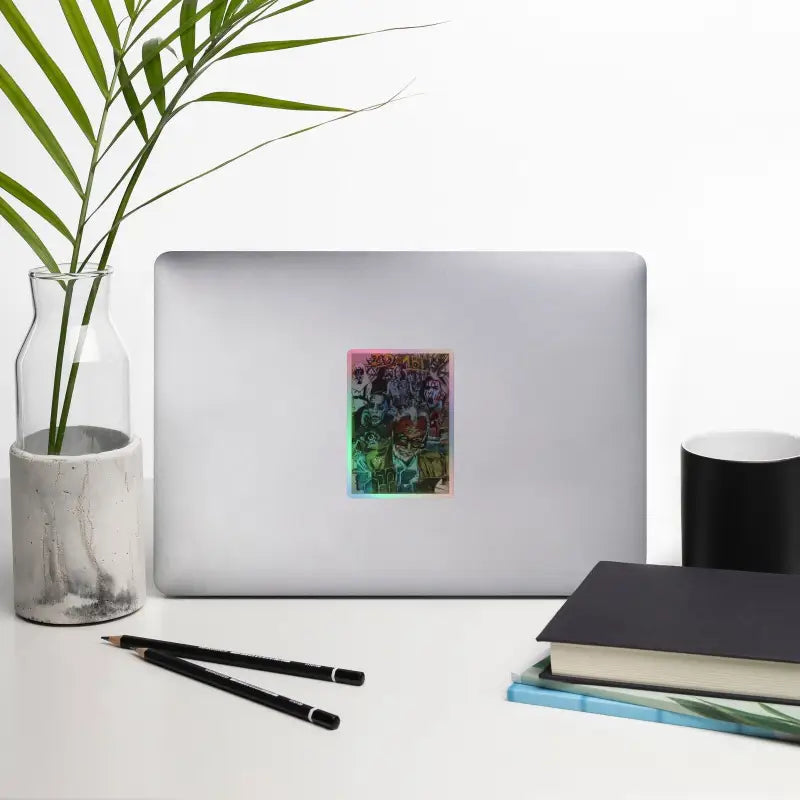 Silver laptop adorned with Romero holographic stickers showcasing vibrant zombie art
