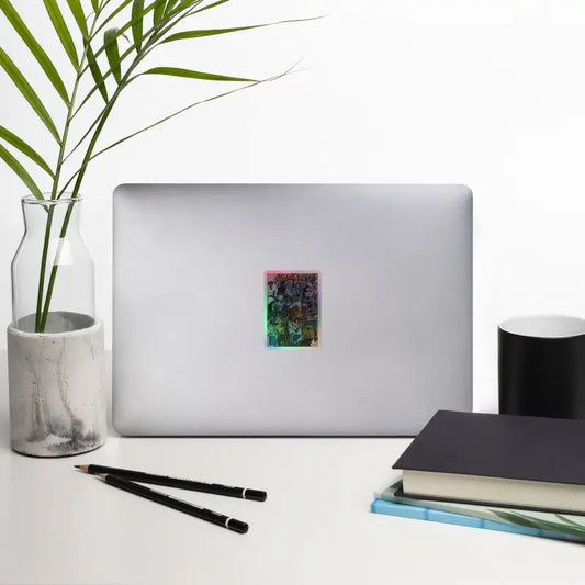 Silver laptop adorned with Romero holographic stickers showcasing colorful zombie art