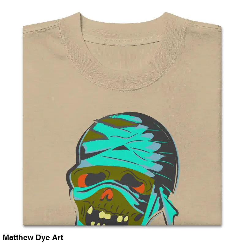 Folded beige mummy unisex oversized faded t-shirt featuring a nostalgic Halloween design