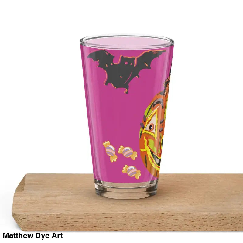 Halloween-themed pint glass featuring an enchanting pumpkin witch design on pink background