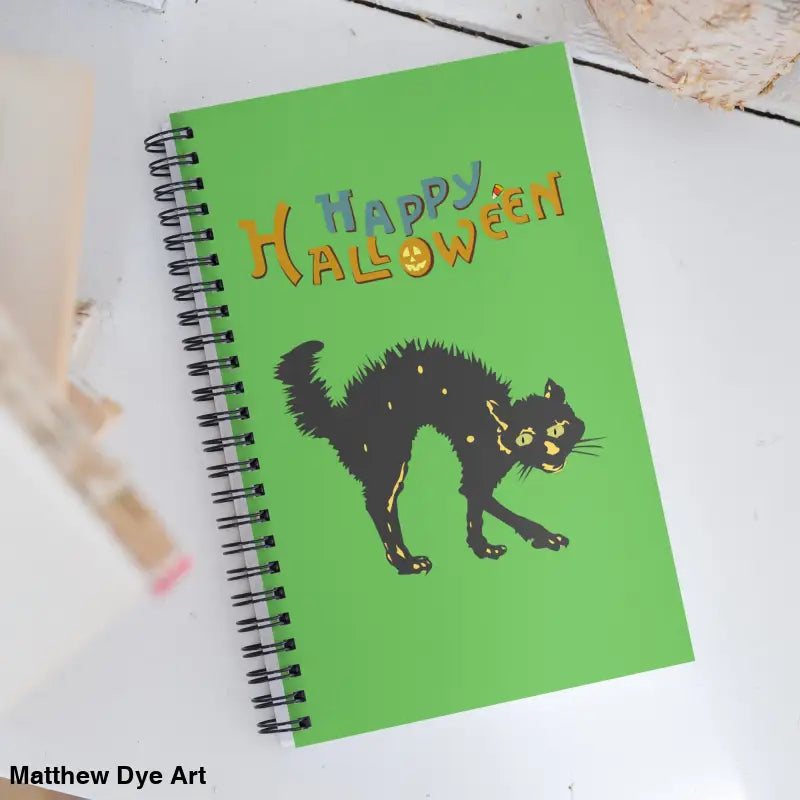 Green Halloween spiral notebook featuring a design of a scary cat for festive creativity