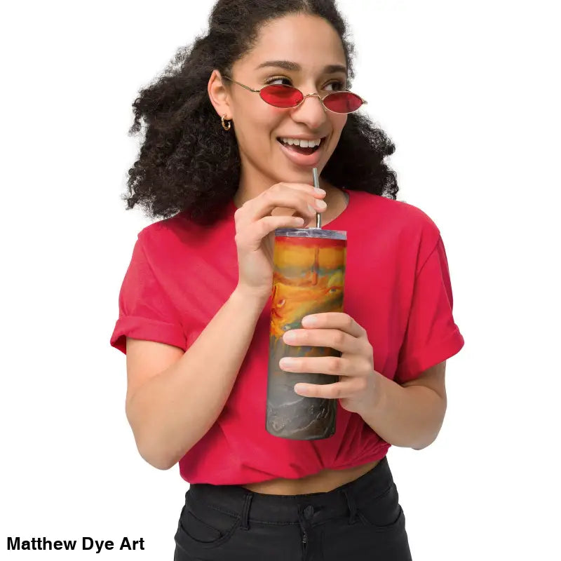 Person in a red t-shirt enjoys a drink from Above the Shadows stainless steel tumbler