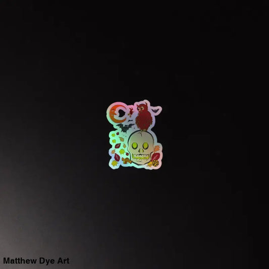 Holographic sticker of a cartoon skull and owl design from Haunted Harvest collection
