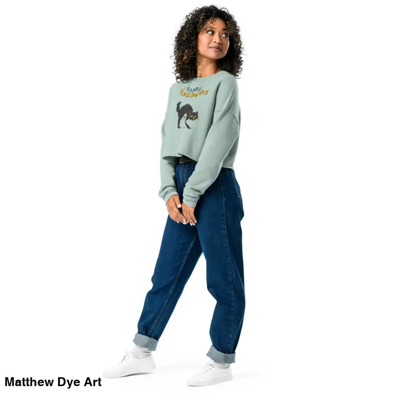 Woman in an Enchanting Mint Green Scary Cat Halloween Cropped Sweatshirt and jeans