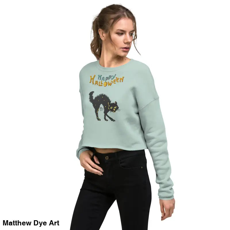 Woman models a Witchy & Wild Scary Cat Halloween cropped sweatshirt in enchanting mint green