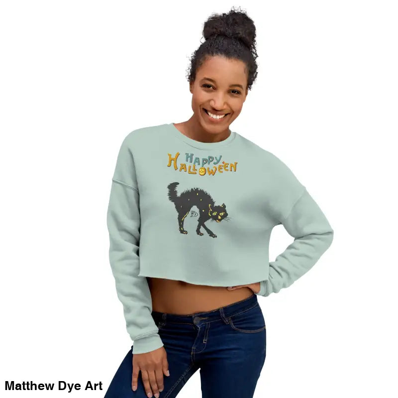Woman in an enchanting mint green cropped Halloween sweatshirt featuring a scary cat design