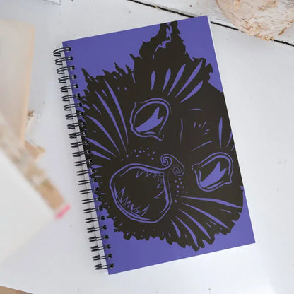 Purple Ah Kitty Spiral Notebook featuring a black cat face for Halloween inspiration