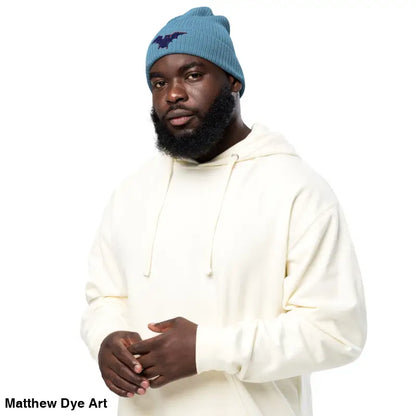 Man in a blue beanie and cream hoodie showcasing the Bat Baby Beanie for autumn warmth