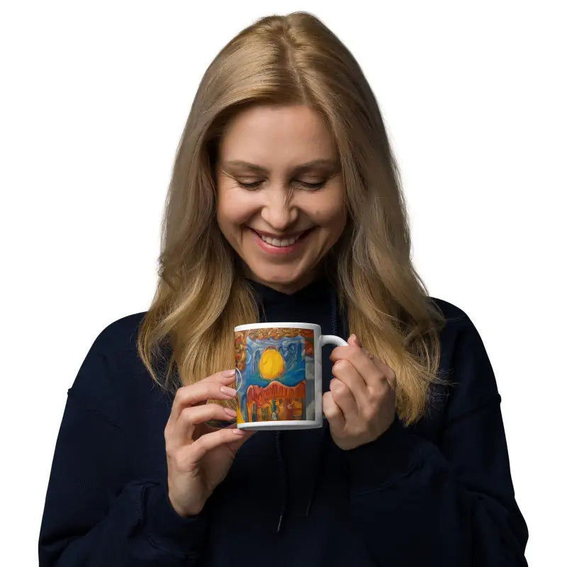 Person in navy sweater smiles with Above and Below Ceramic Mug by Matthew Dye