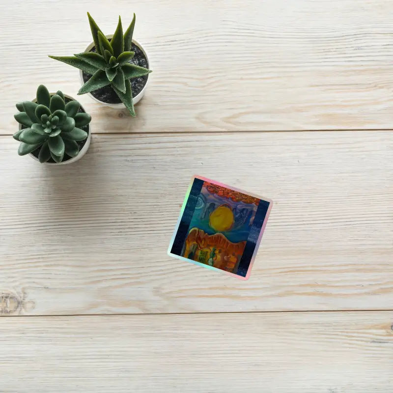 Two small potted succulents and a colorful CD case showcasing Cosmic Holographic Stickers