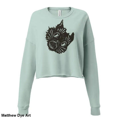 Light blue cropped sweatshirt featuring black graphic of surreal cat design for spooky season style