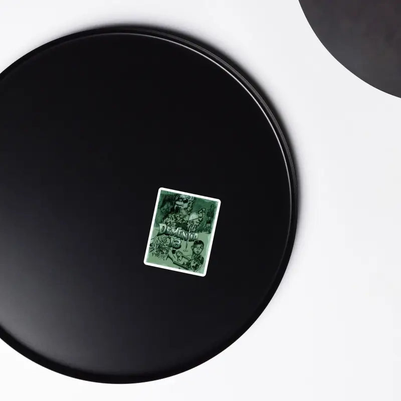 Black circular disc with a green card, featuring Dementia 13 Retro Horror Magnets