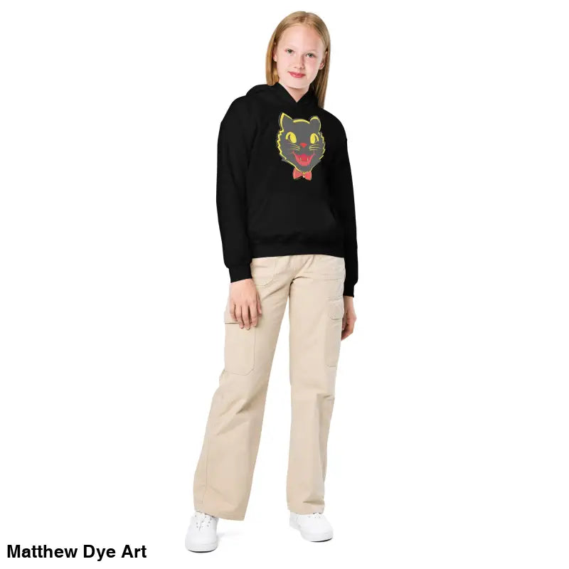Girl wearing Little Trickster Vintage Halloween Cat Youth Hoodie with khaki pants