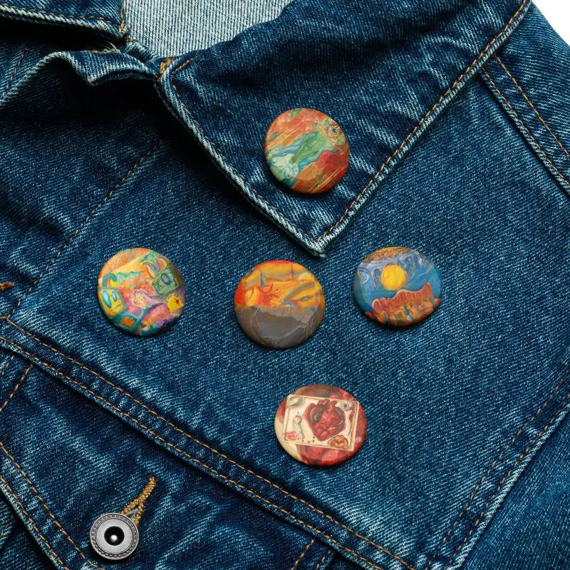 Colorful marbled art pins by Matthew Dye displayed on denim fabric in a surreal arrangement