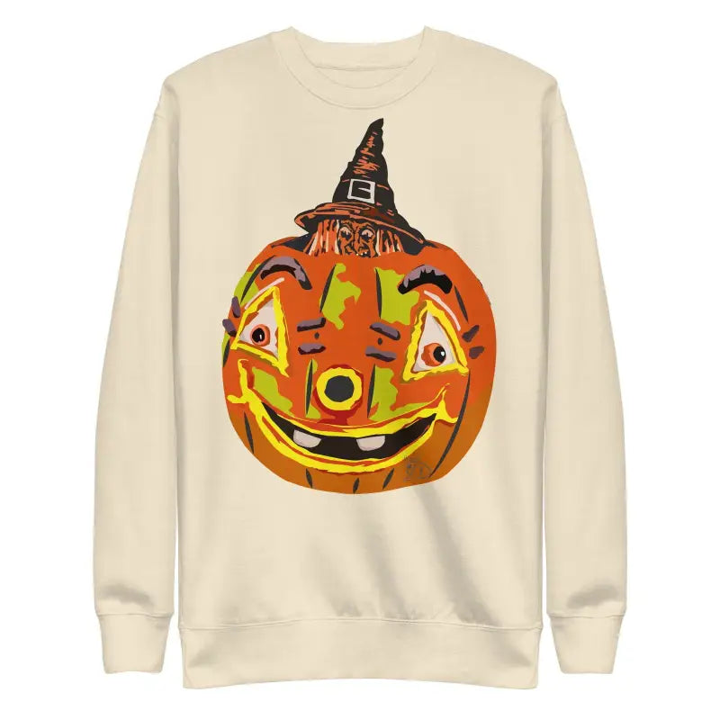 Cream-colored unisex premium sweatshirt with a smiling pumpkin witch in a witch hat