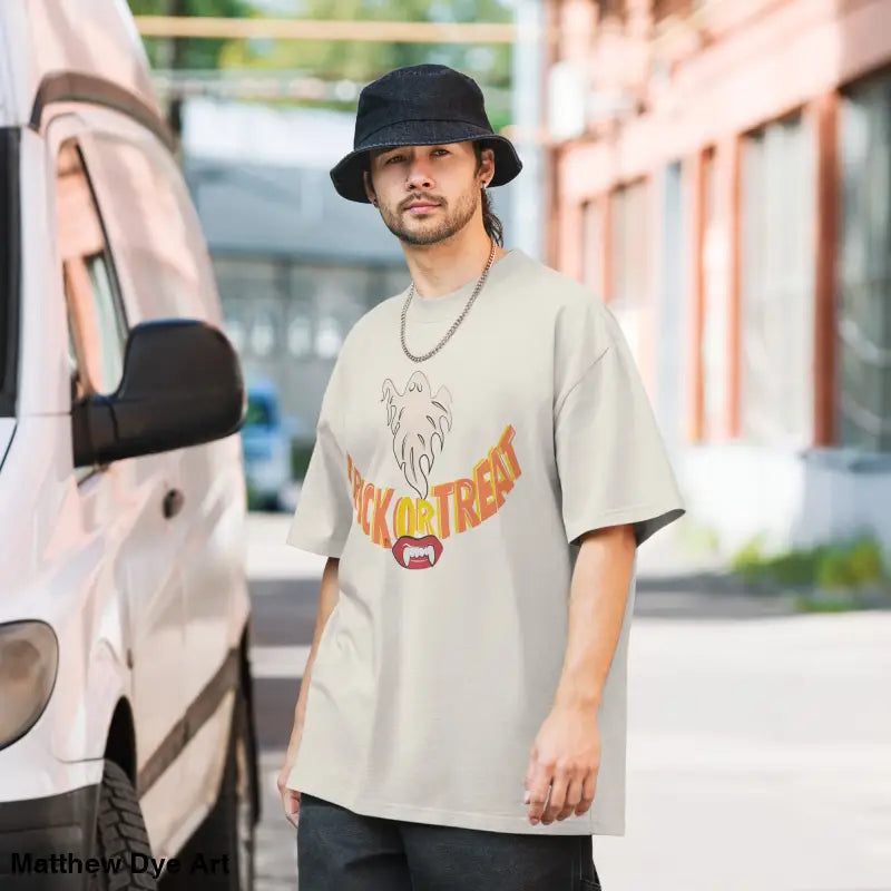 Man wearing oversized faded t-shirt featuring vampire fangs for Halloween treat smiles