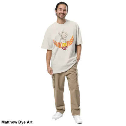 Man in oversized faded t-shirt with Trick or Treat design and cargo pants for Halloween