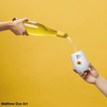 White wine being poured into Pharaoh’s Curse Tumbler, featuring Matthew Dye art