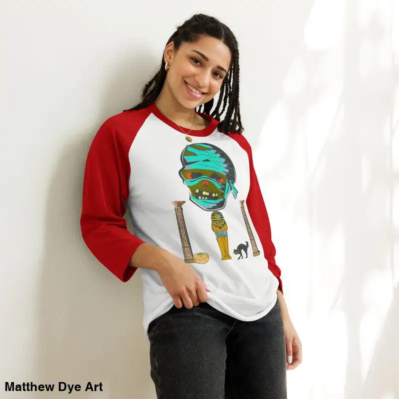 Red and white raglan shirt featuring Matthew Dye art of a mystical mummy charm