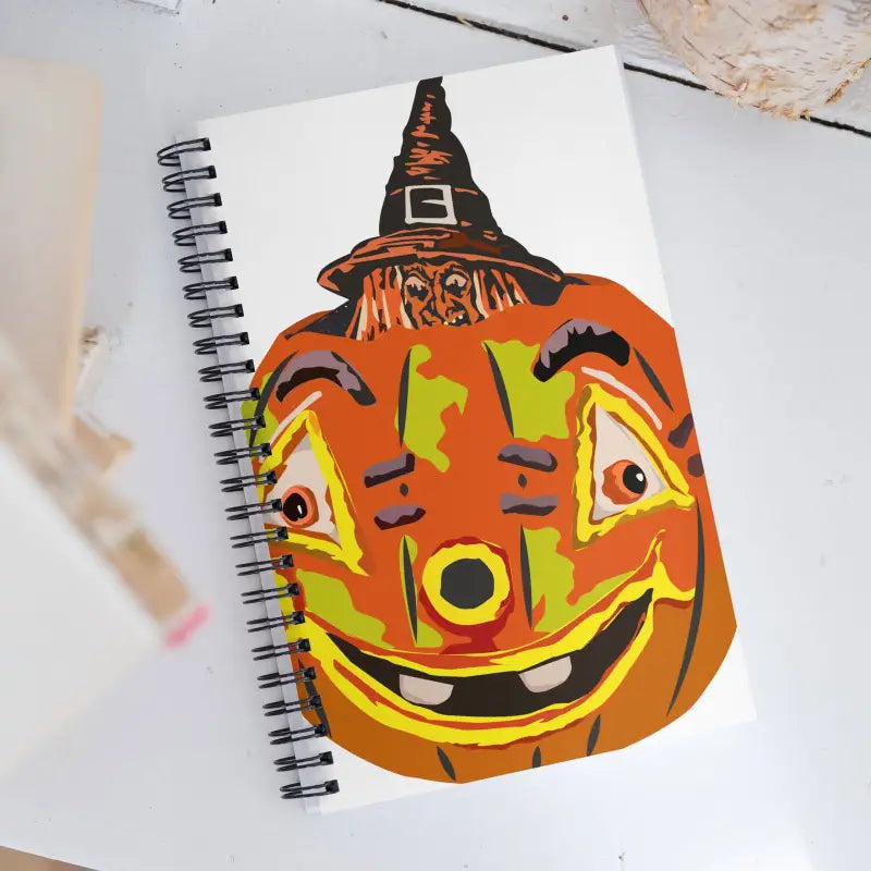 Spiral notebook featuring a smiling pumpkin witch in a whimsical design