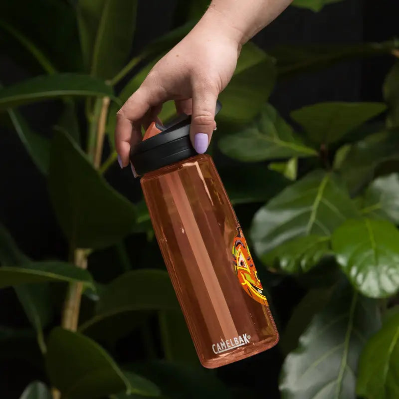 Brown Pumpkin Witch Sports water bottle held by a hand for stylish hydration