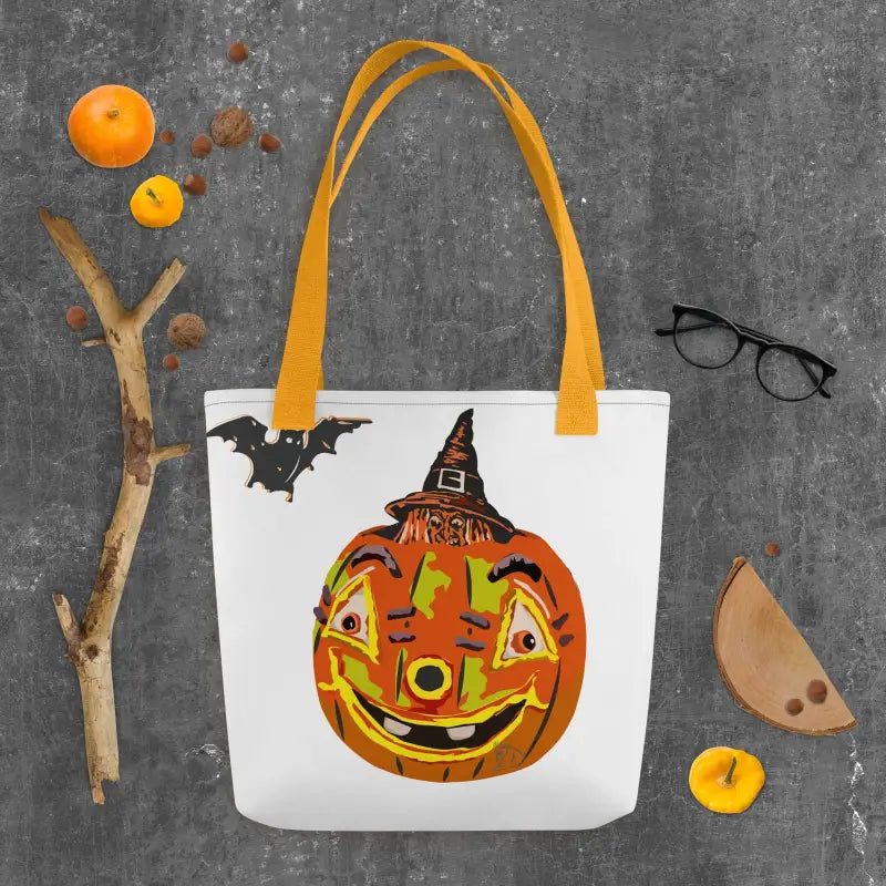 White tote bag with yellow handles featuring a pumpkin witch, embodying vintage Halloween charm