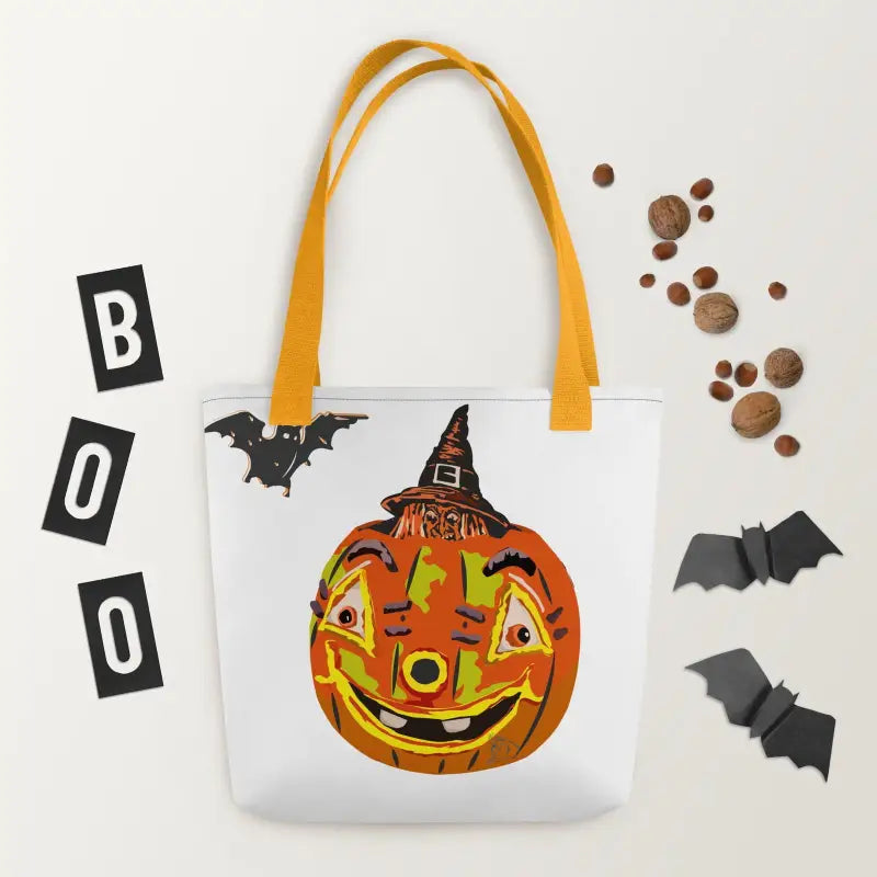 White tote bag featuring a smiling pumpkin design with yellow handles and vintage Halloween charm