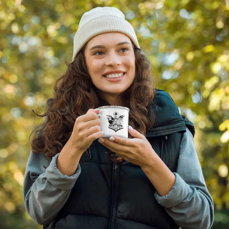 White enamel cup with butterfly design held in hands, perfect for Viking adventures