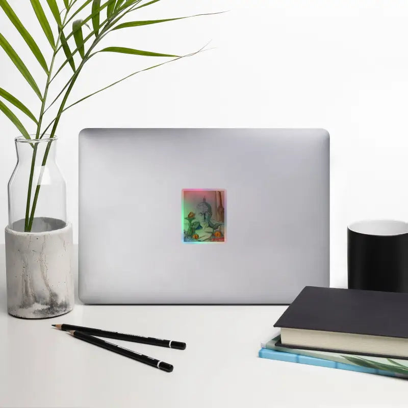 Silver laptop adorned with a phrenology holographic kiss-cut sticker, showcasing enchanting stillness