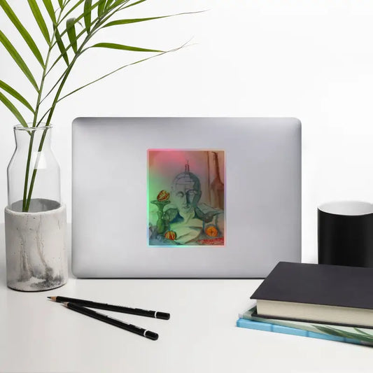 Silver laptop displaying a colorful Buddha sticker from Serenity’s Holographic Kiss-Cut collection