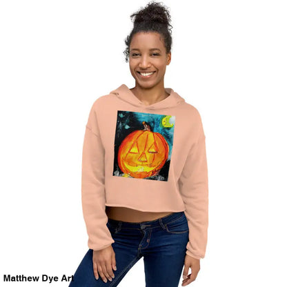Peach-colored cropped hoodie featuring a spooky cute jack-o’-lantern design by Matthew Dye Art