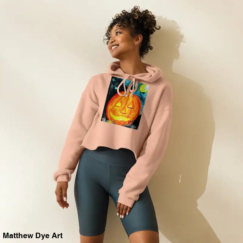 Woman in pumpkin hoodie with jack-o’-lantern design and bike shorts, showcasing spooky cute style