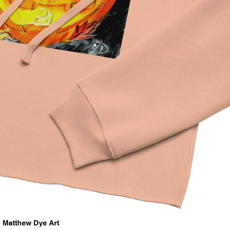 Peach-colored cropped hoodie featuring spooky cute Jack-o’-lantern design by Matthew Dye Art