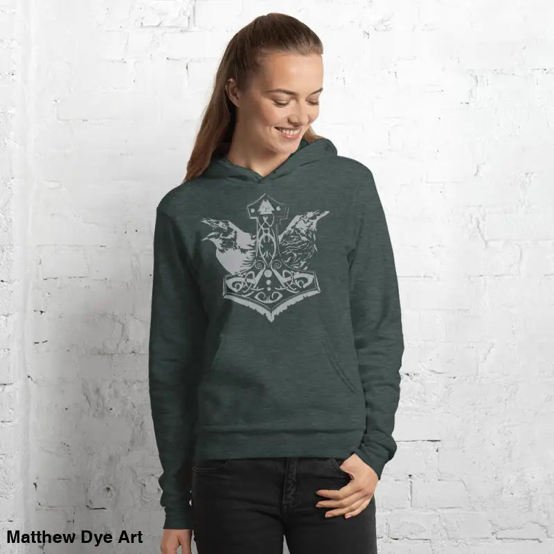 Woman in a dark green comfortable Viking unisex pullover hoodie featuring Thor’s Mjolnir and Odin’s Ravens