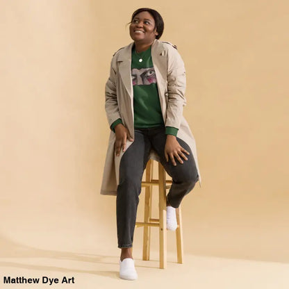 Woman in green sweatshirt and trench coat showcasing urban elegance in classic sweatshirt silhouette